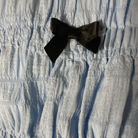 Light blue stretchy shorts with a small cute black bow. - Picture 2 of 5